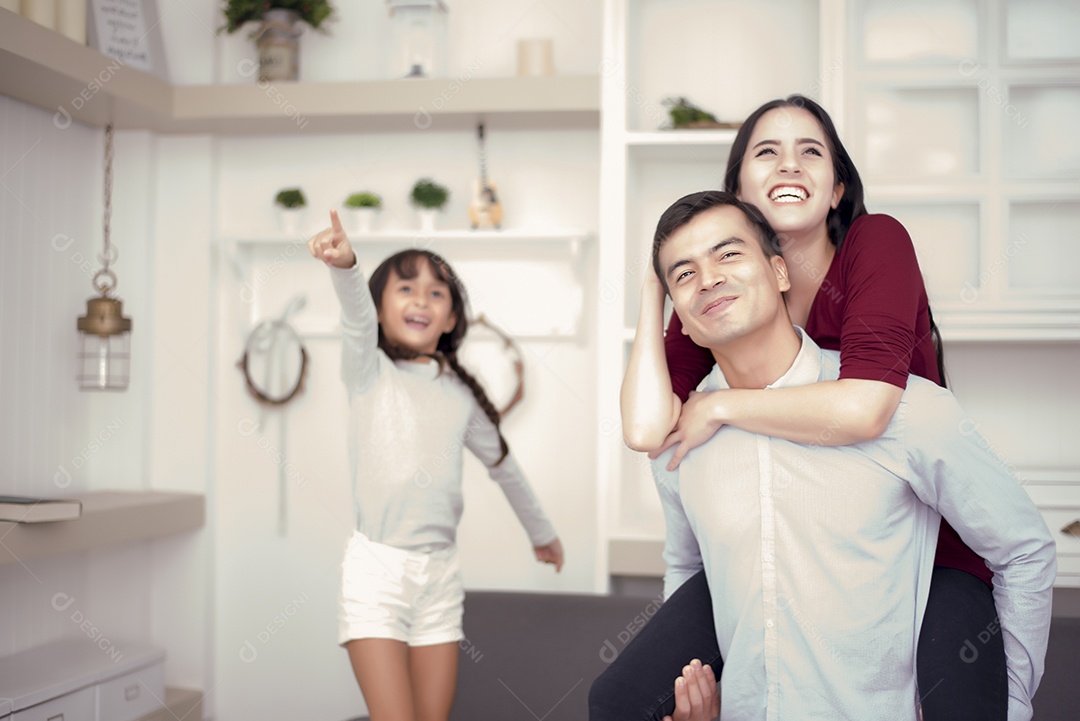 Família feliz olhando para fora com bom humor, mãe voltando para o pai, garotinha apontando para o lado de fora com humor de rosto feliz, foco seletivo do conceito de família e felicidade.