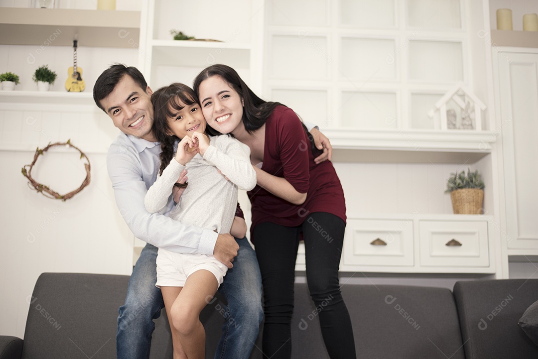 Três membros da família feliz de bom humor com abraço, sorrindo juntos Mãe, pai e filha agindo como conceito de felicidade.