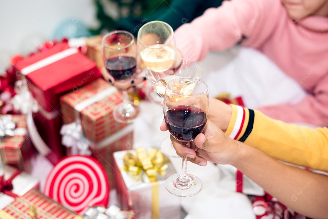 Mãos de pessoas comemorando a festa de ano novo em casa com copos de vinho. Ano novo e conceito de festa de Natal.