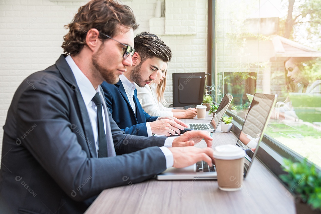 Grupo de empresários trabalhando com laptops modernos no escritório. Conceito de trabalho em equipe e cooperação.