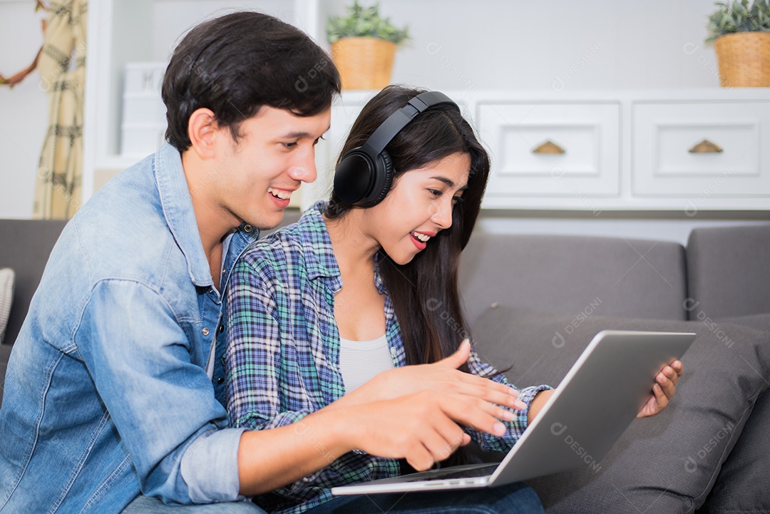 Amantes ou casal usando laptop e ouvindo música com fone de ouvido em casa. Conceito de lua de mel e entretenimento.