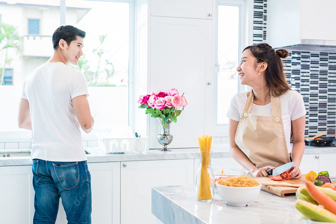 Amantes asiáticos ou casais cozinhando tão engraçados juntos na cozinha com muitos ingredientes na mesa. Conceito de lua de mel e felicidade.