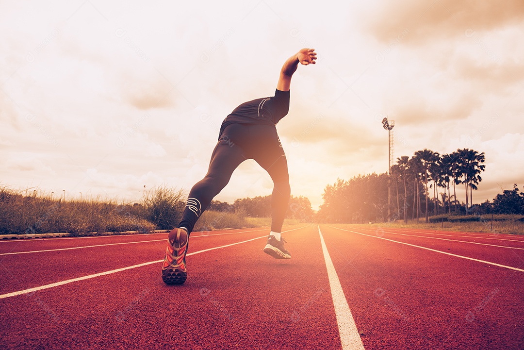 Pôr do sol e jovem correndo na pista. Sucesso e objetivo do conceito de negócio. Esporte atlético e tema de exercício.