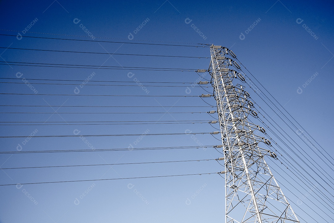 Cabo e poste de telecomunicação elétrica de fio com fundo de céu azul.