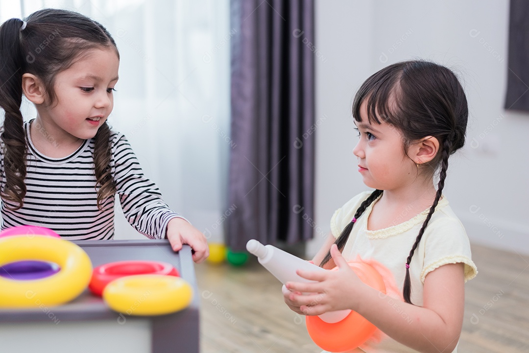 Duas meninas jogando pequenas bolas de brinquedo em casa juntos. Conceito de estilo de vida de educação e felicidade.