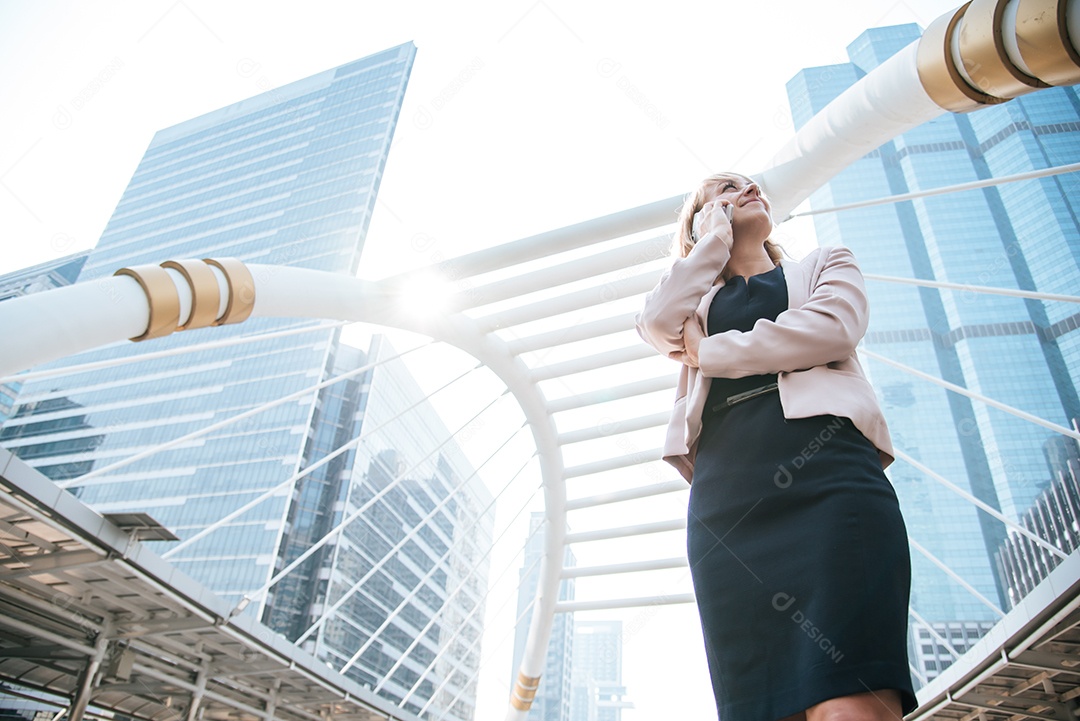 Empresária de beleza usando telefone celular para se comunicar com os clientes da cidade. Conceito de negócios e tecnologia. tema metrópole.