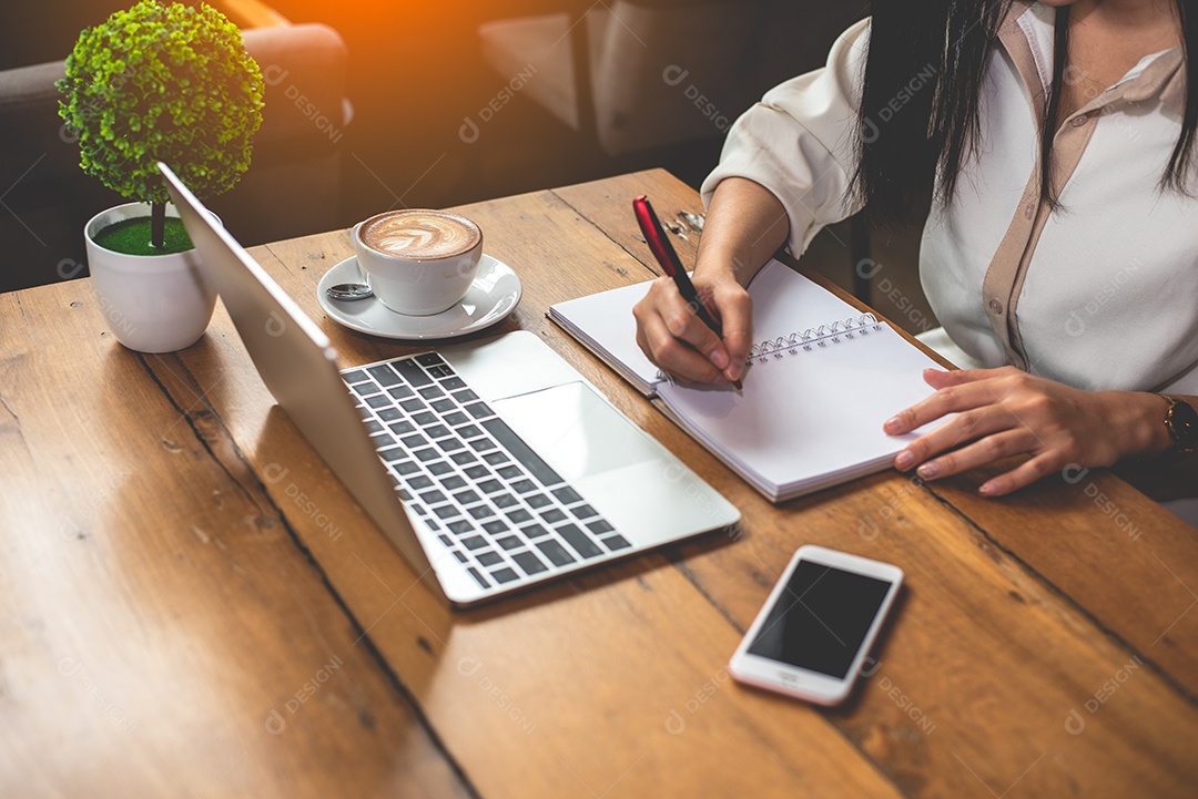 Close-up da mulher de negócios trabalhando com documentos e laptop no escritório.
