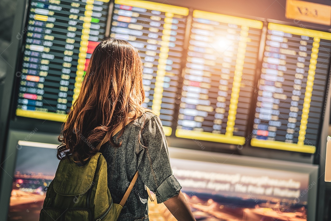 Turismo feminino de beleza olhando horários de voo para verificar o tempo de decolagem.