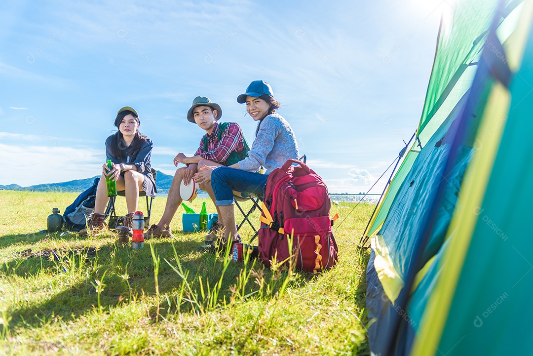 Grupo de viajantes acampar e fazer piquenique no Prado com primeiro plano de tenda. Fundo de montanha e lago.