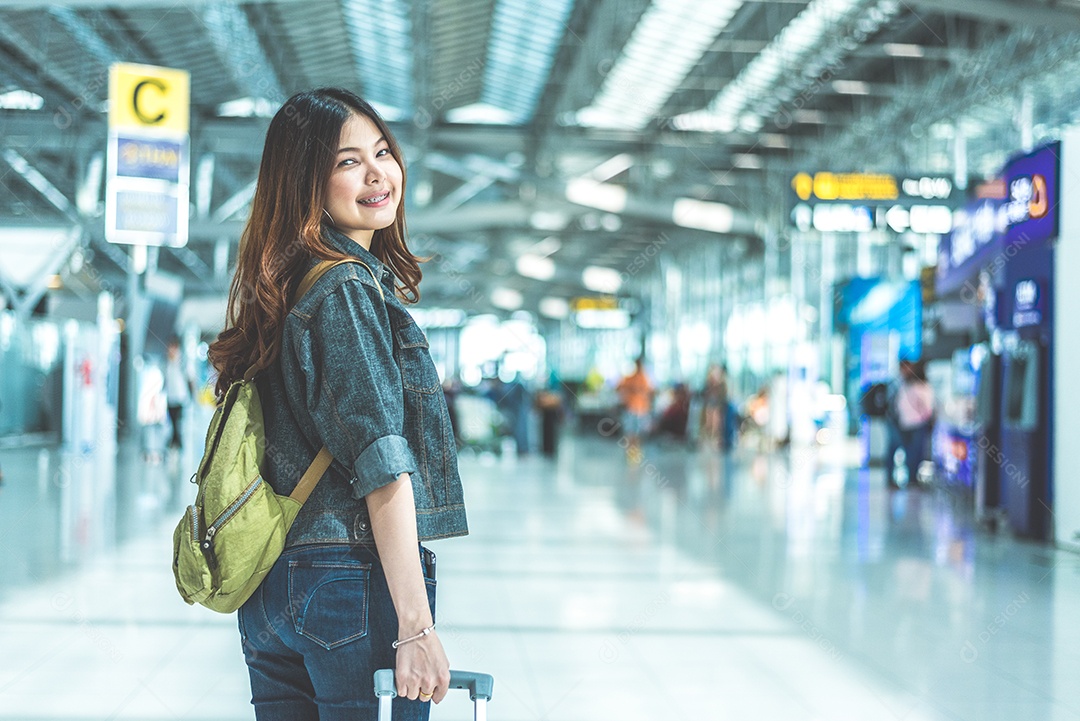 Mulher asiática de beleza viajando e segurando a mala no aeroporto.