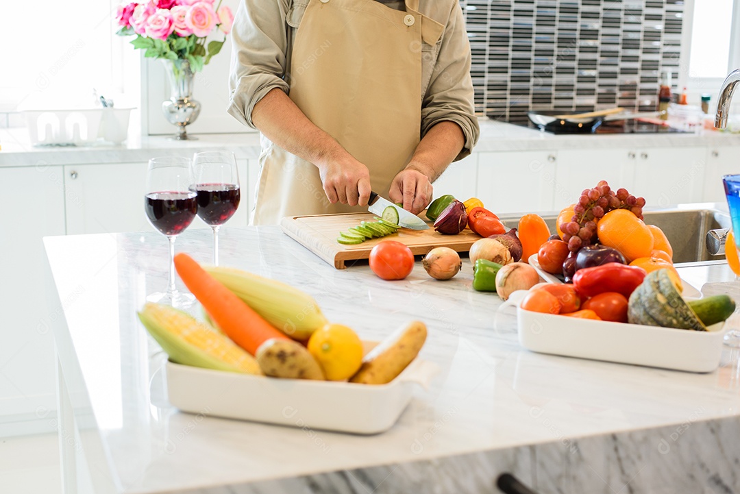 Homem cozinhando e cortando vegetais na cozinha. Conceito de pessoas e estilos de vida. Tema de comida e bebida.
