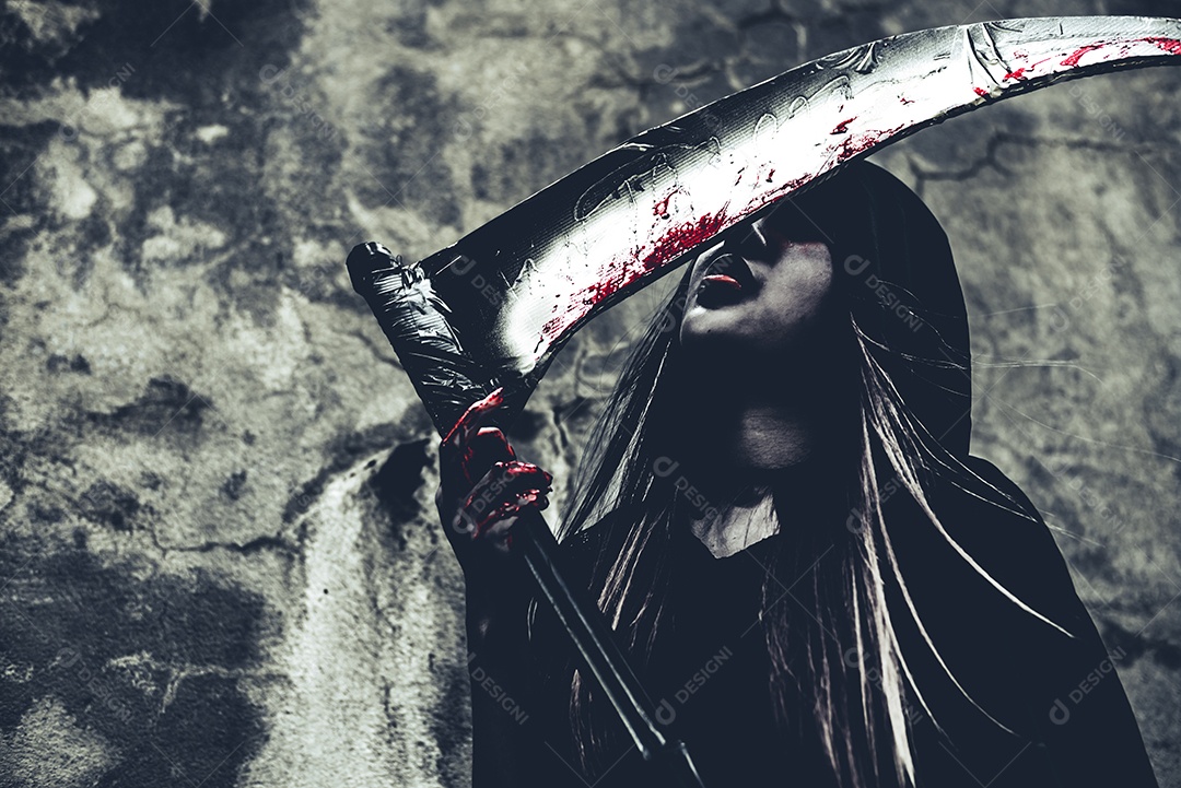 Bruxa lambendo sangue no Ceifador. Anjo demônio feminino em roupas pretas e capuz no fundo da parede do grunge.