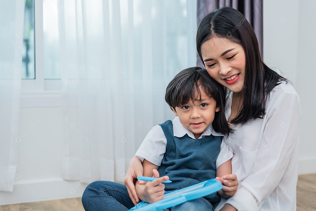 Mãe asiática ensinando menino bonito a desenhar juntos na lousa. De volta à escola e ao conceito de educação.