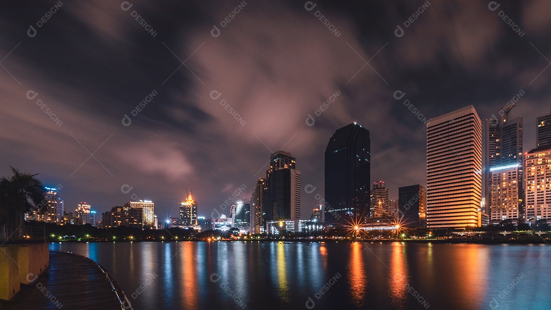 Cidade grande na vida noturna com reflexo da onda de água. Técnicas de longa exposição. Panorama da paisagem.