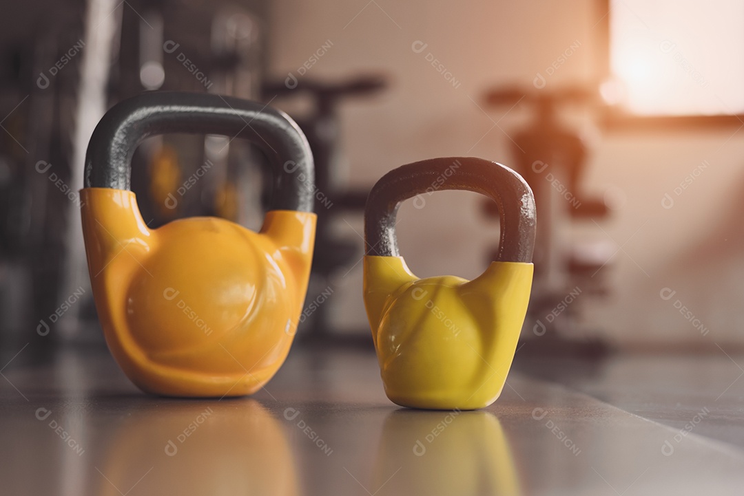 Kettlebells ou halteres no chão do ginásio de fitness. Equipamentos esportivos pesados ​​e acessórios no clube de treinamento de exercícios.