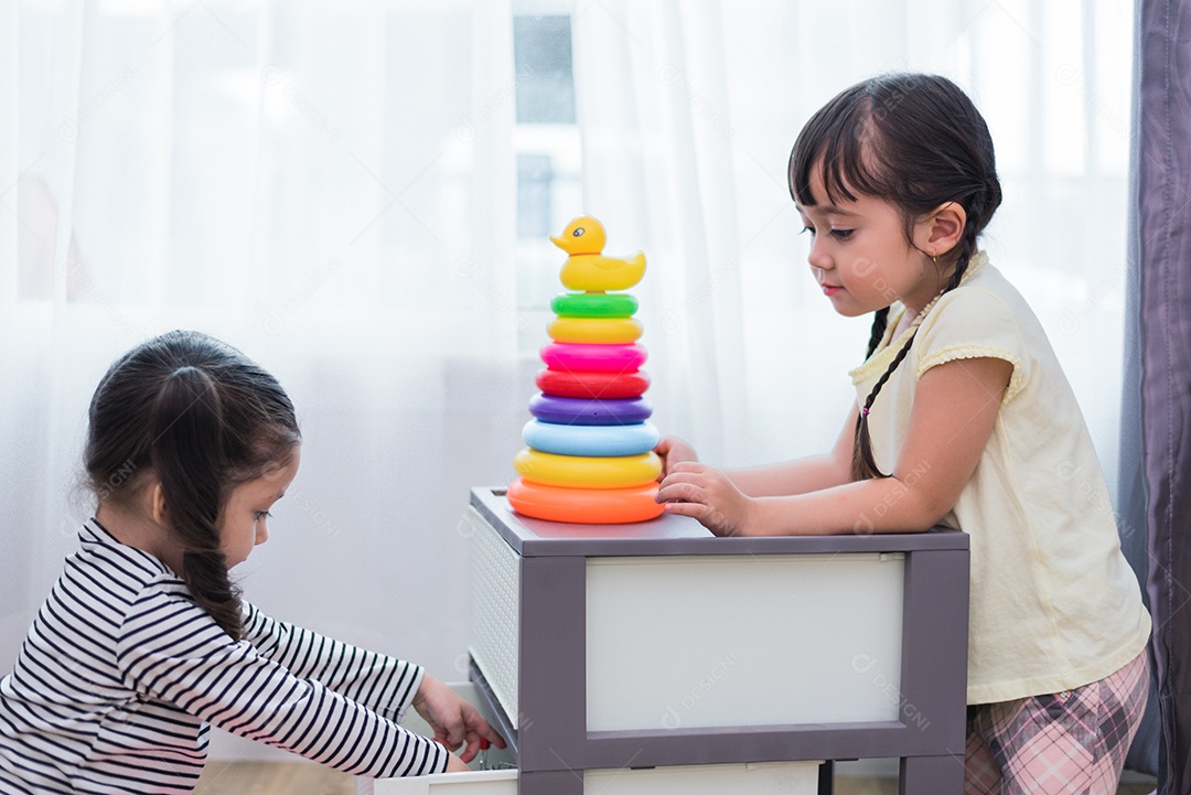 Duas meninas jogando pequenas bolas de brinquedo em casa juntos.