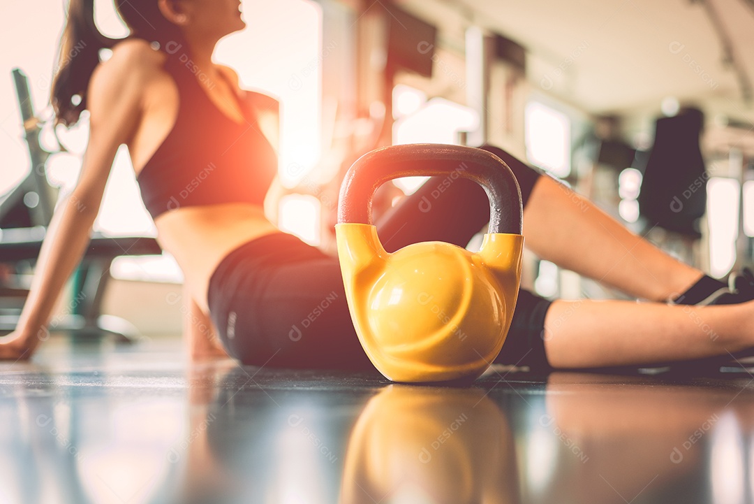 Close-up kettlebells com treino de exercício de mulher na quebra de fitness de ginásio relaxe após o fundo do centro de treinamento esportivo.