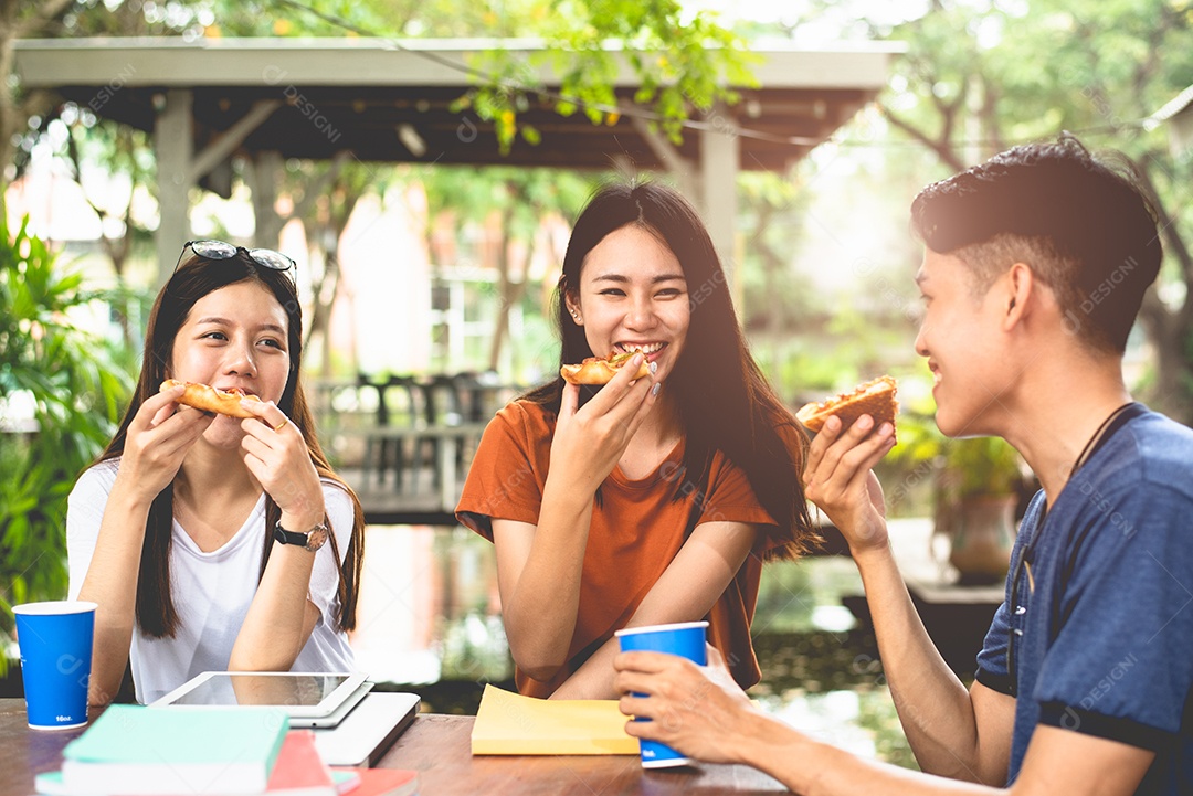 Jovens asiáticos comendo pizza juntos pelas mãos. Conceito de festa de comemoração de comida e amizade.