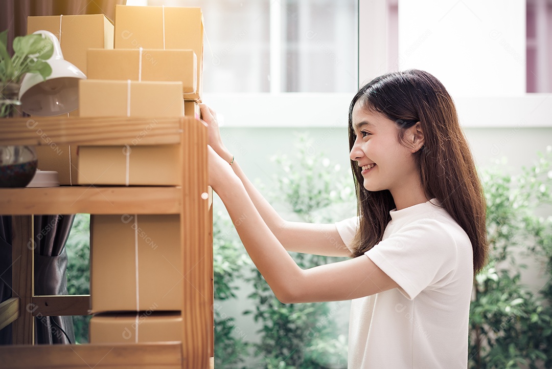 Mulher asiática colocou nota de papel de memorando pegajoso na caixa de correio do pacote e pronta para enviar ao cliente.
