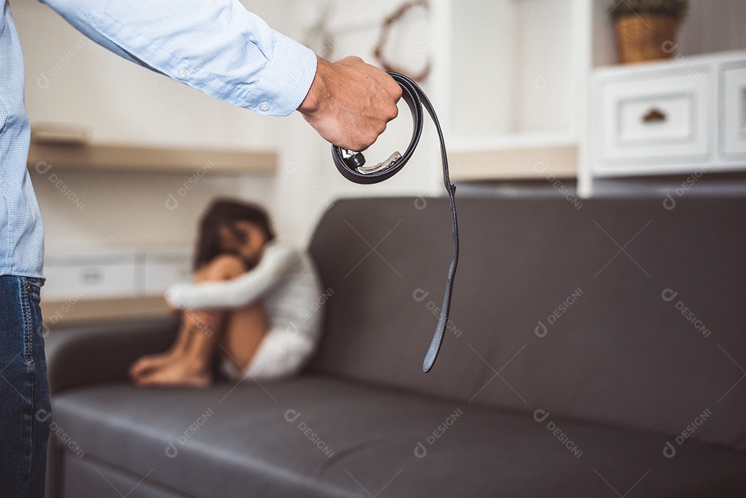 Menina temendo que seus pais sejam punidos no sofá em momento dramático.