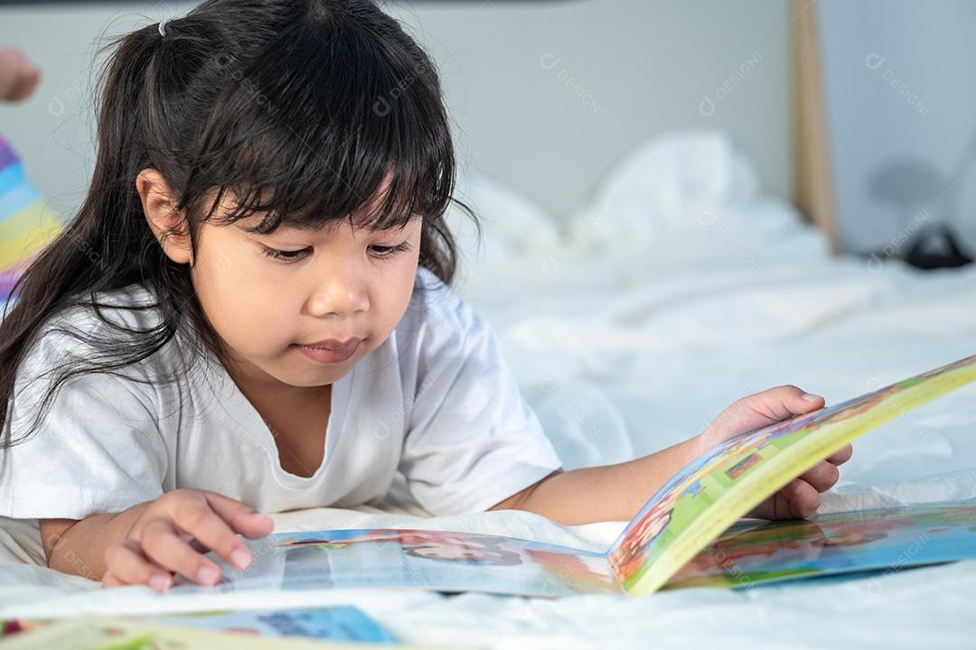 Menina asiática bonitinha lendo contos de fadas na cama branca no quarto, estudo, hobbies, lazer