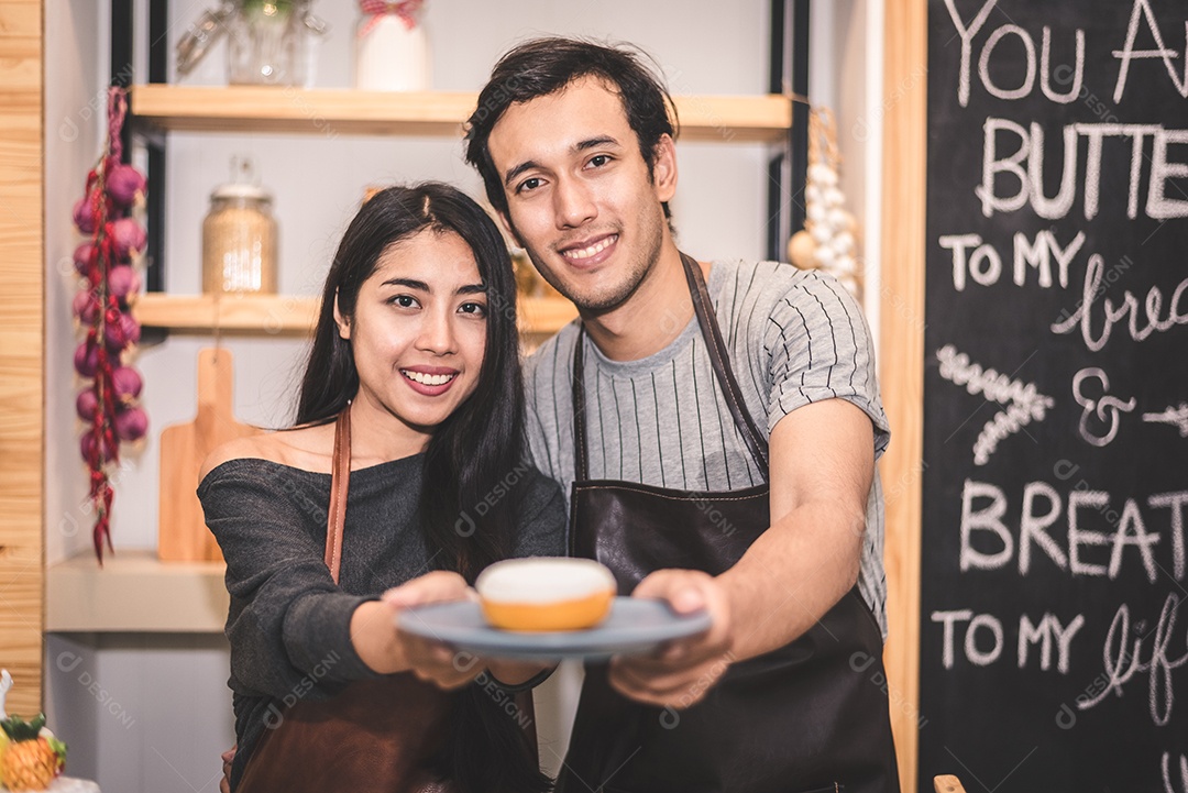 Jovens casais fazendo rosquinhas de padaria e pão na padaria como empresário. Marido e mulher cozinhando juntos na cozinha.