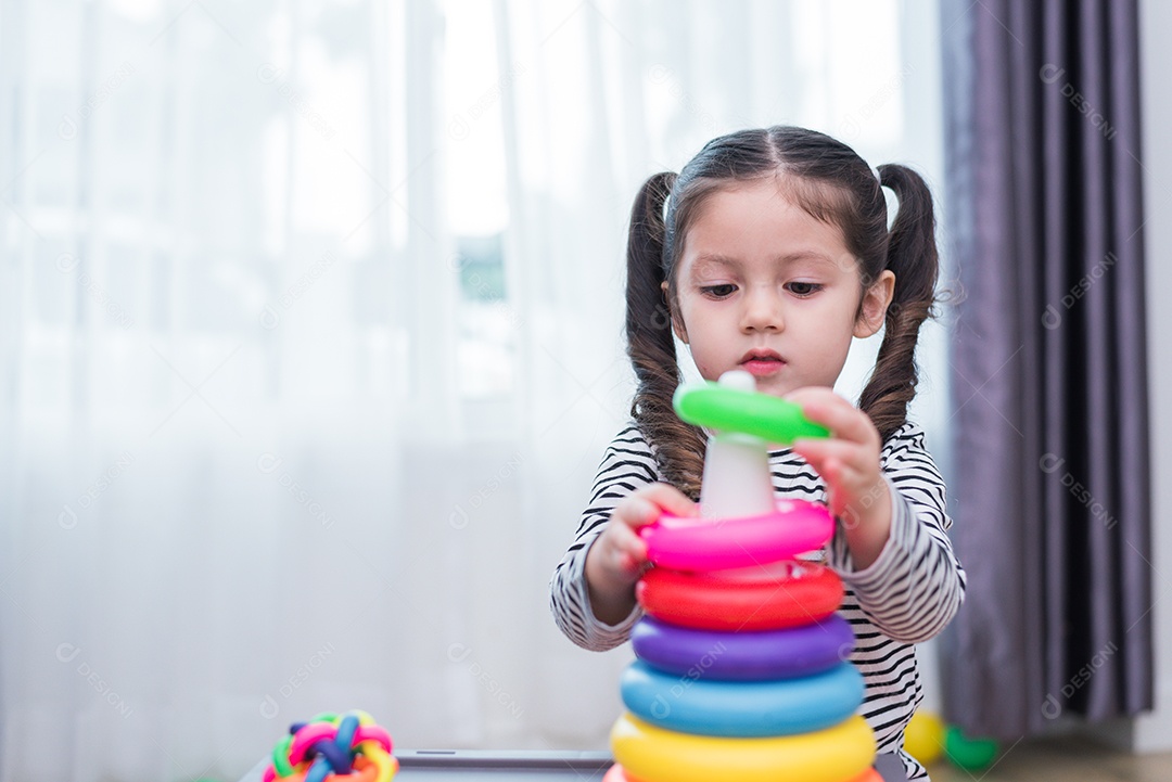Little girl playing small toy hoop at home. Education and Happiness.