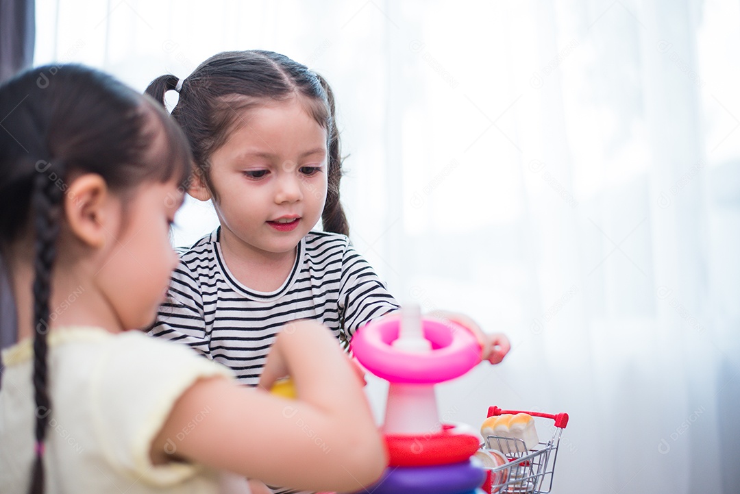 Duas meninas jogando aros de brinquedo em casa juntos.
