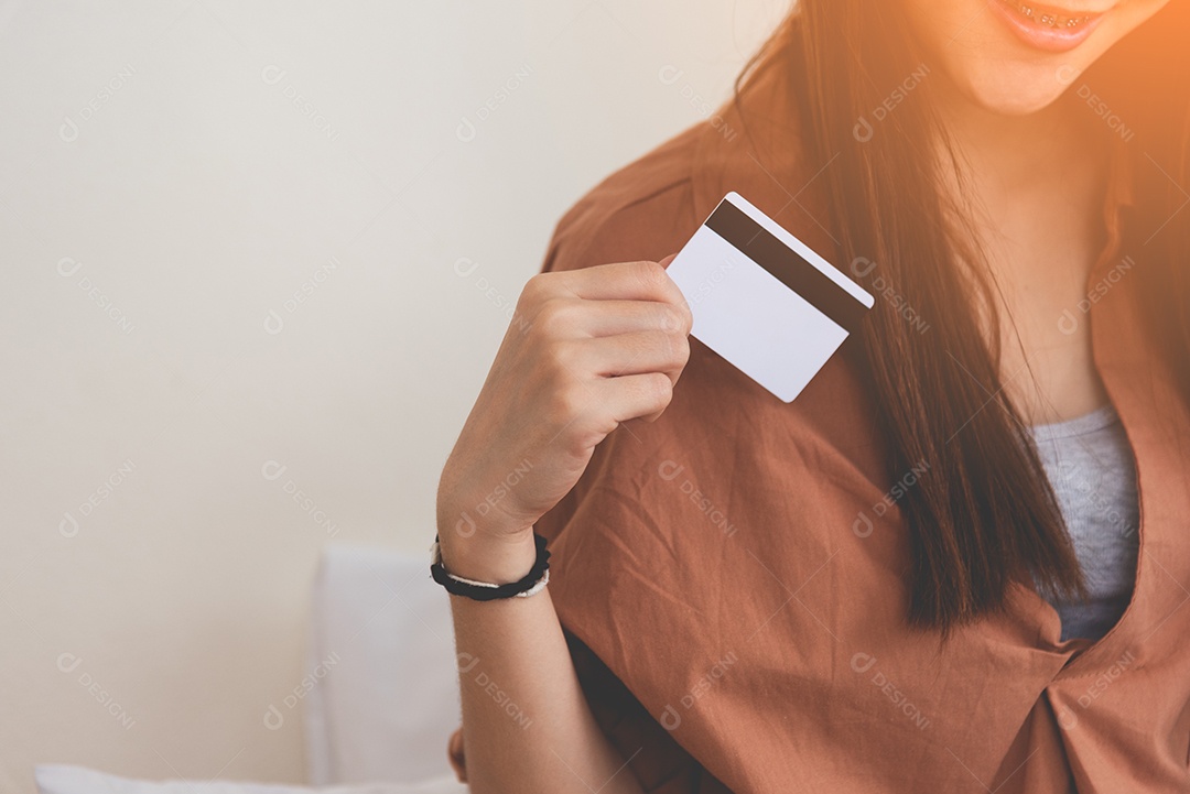 Jovem mulher feliz usando cartão de crédito. Negócios e compras online.