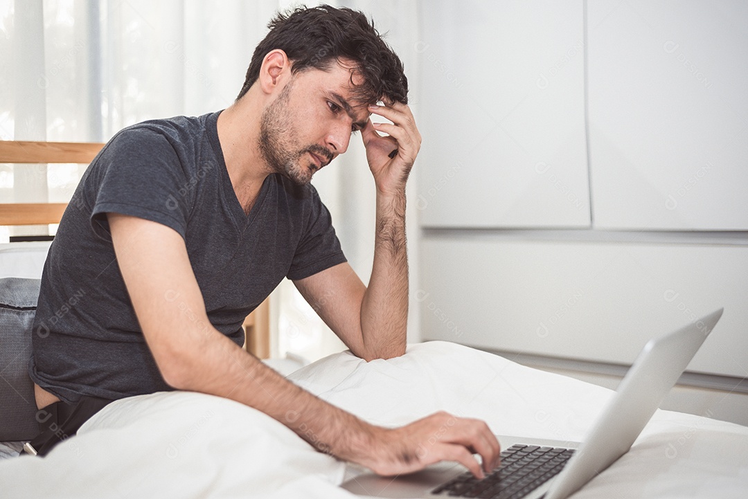Homem estressado do trabalho com laptop no quarto.
