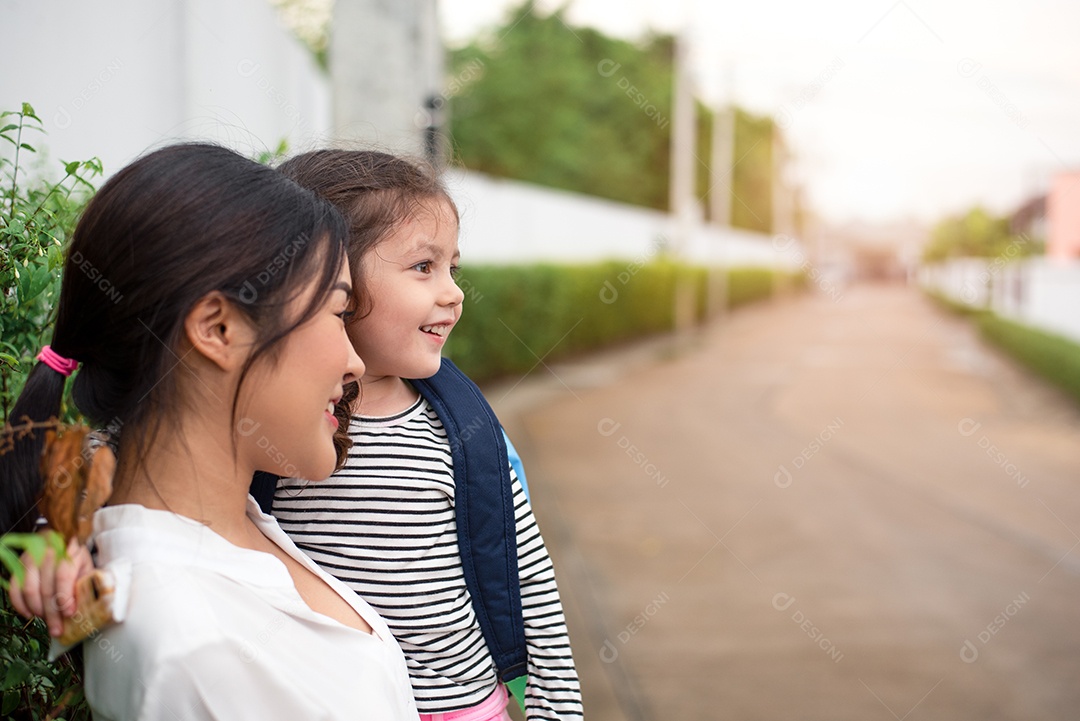 Mãe e filha sorrindo juntas depois de ir para casa da escola. Conceito de amor e creche. Família feliz e tema Lar doce lar.