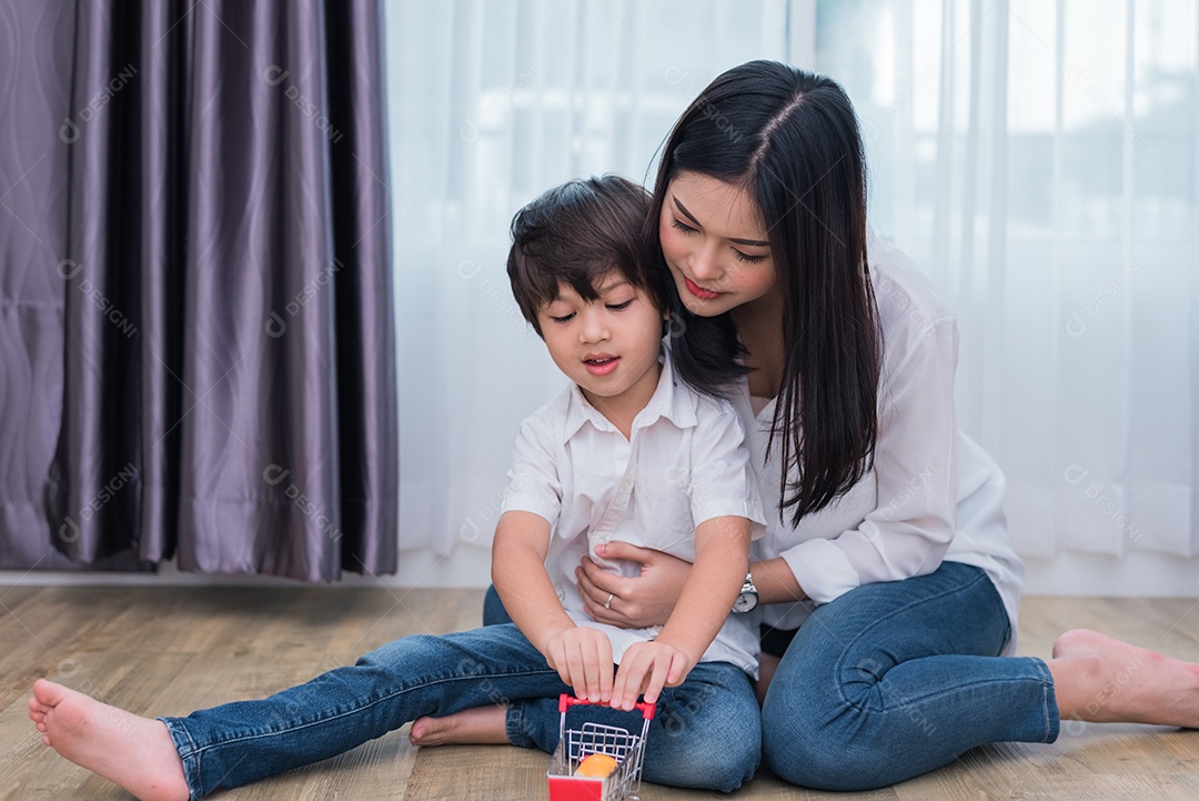 Jovem mãe asiática e filho brincando de brinquedo em casa.
