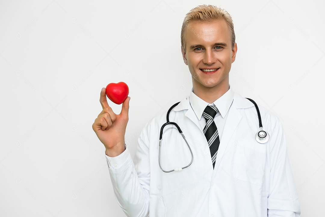 Médico masculino bonito segurando coração vermelho e sorrindo. Cuidados de saúde e conceito médico.