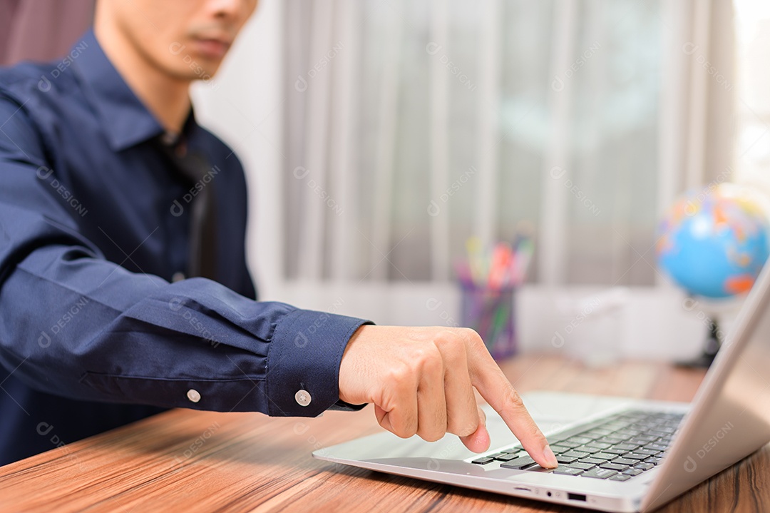 Homem de negócios que usa o computador portátil no escritório