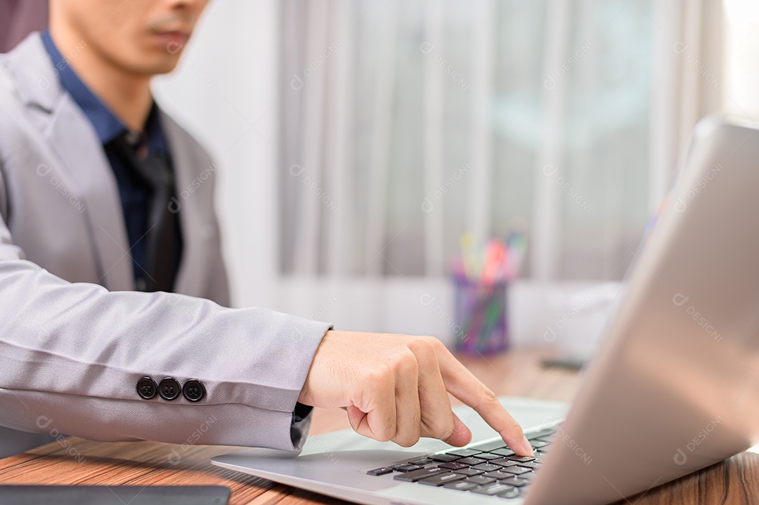 Homem de negócios que usa o computador portátil no escritório