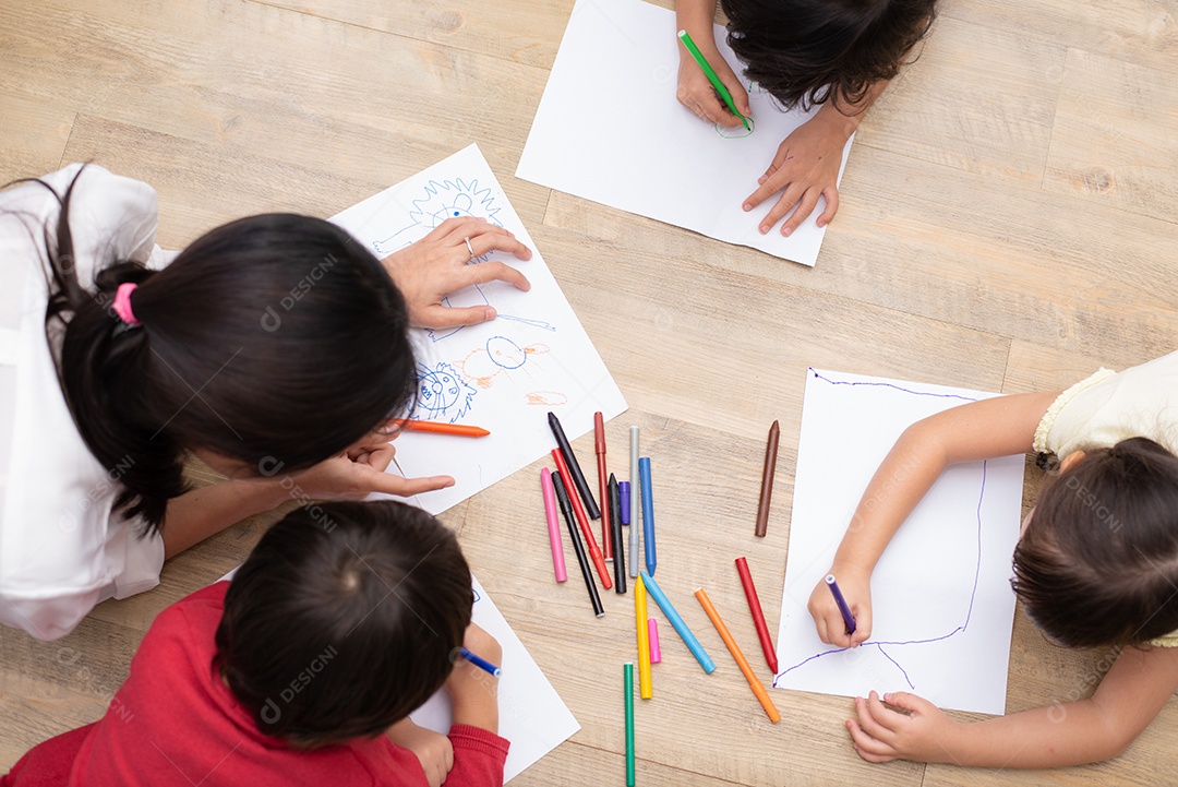 Grupo de alunos da pré-escola e professores desenhando em papel na arte c.