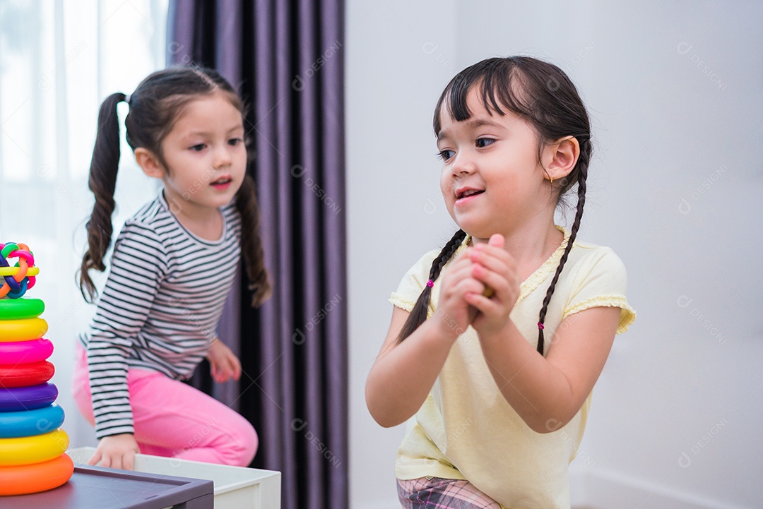 Duas meninas jogando pequenas bolas de brinquedo em casa juntos.