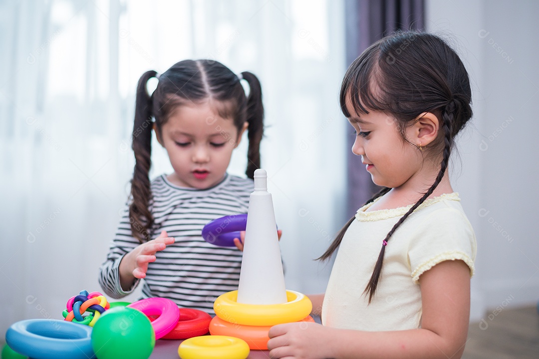 Duas meninas jogando pequenas bolas de brinquedo em casa juntos.