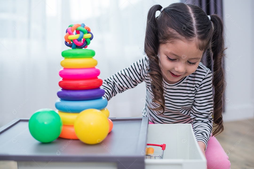 Meninas jogando pequenos aros de brinquedo em casa. Educação e felicidade.