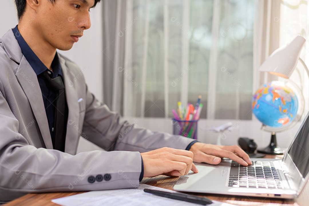 Empresário trabalhando na frente de um notebook em uma mesa