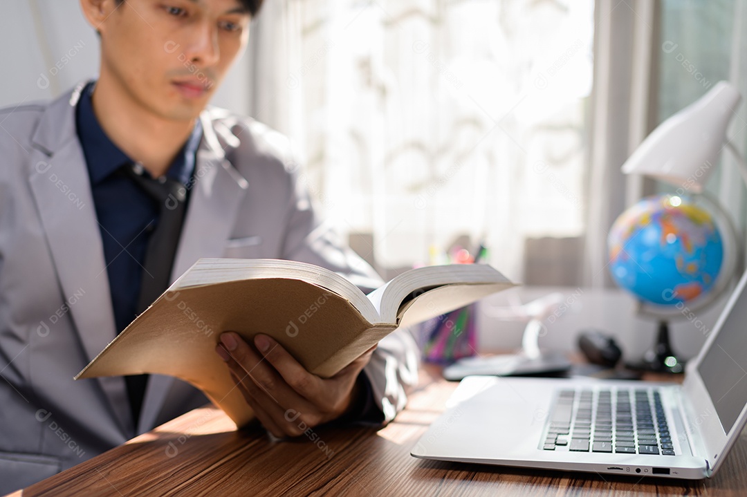 Homem de negócios lendo um livro em sua mesa
