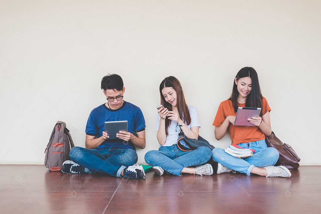 Group of Asian college students using tablet and cellphone.