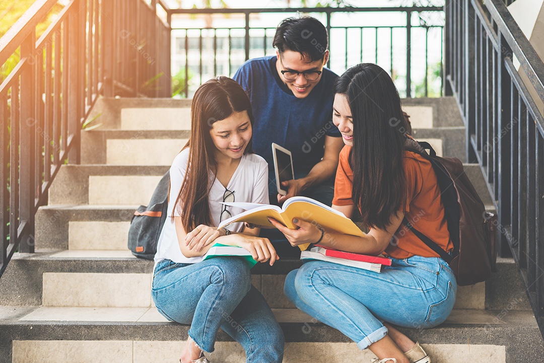 Group of Asian college students using tablet and cellphone.