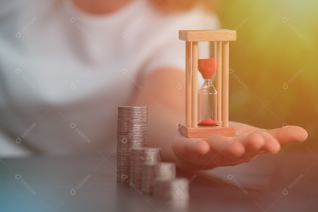 Uma ampulheta repousa na mão de uma mulher