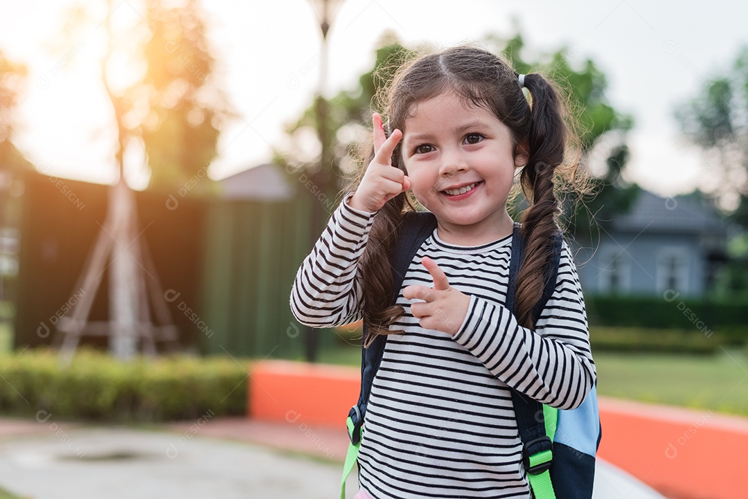 Menina feliz gosta de ir à escola. De volta à escola.