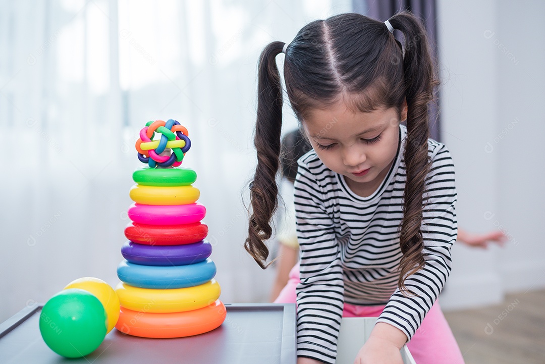 Meninas jogando pequenos aros de brinquedo em casa. educação e felicidade.