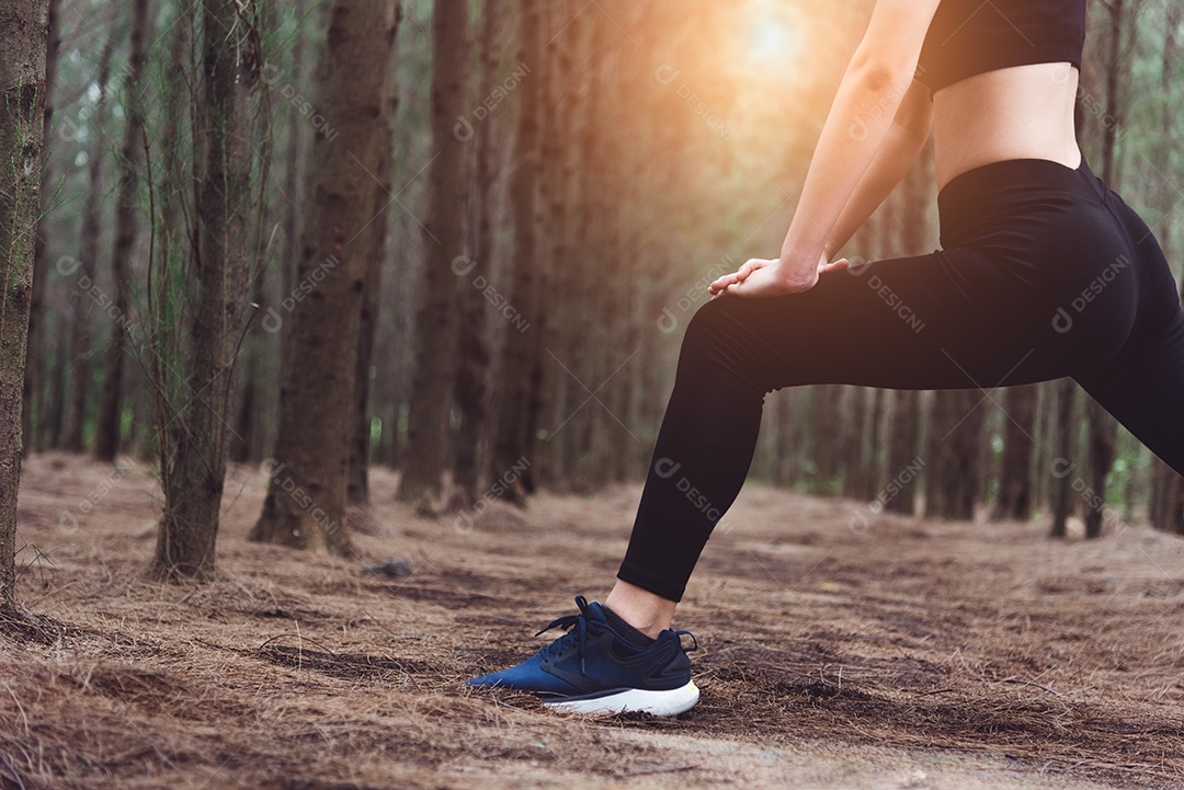 Close-up da parte inferior do corpo da mulher fazendo ioga e esticando as pernas.