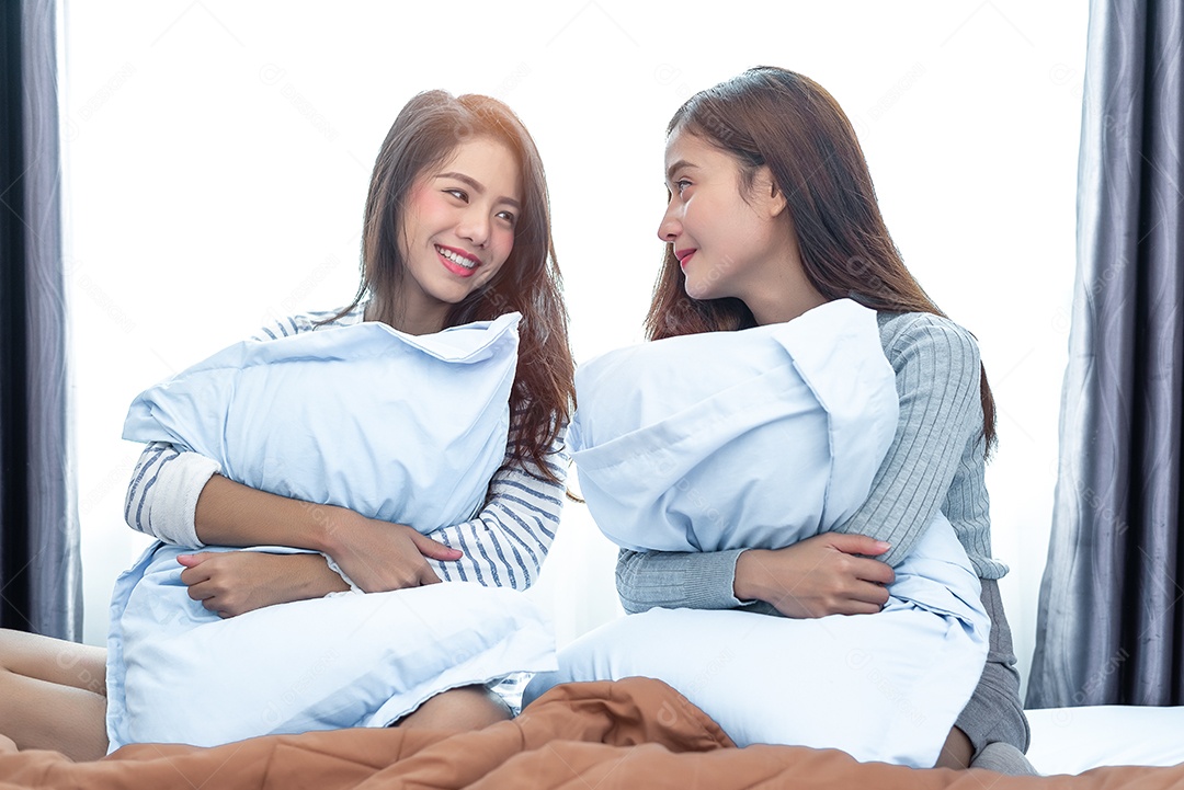 Duas mulheres lésbicas asiáticas olhando juntas no quarto.