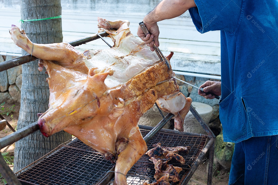 Homem grelhar carne de porco grelhada na rua ao ar livre. Alimentação e ocupação.