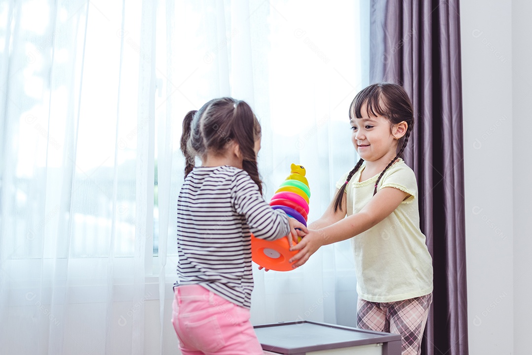 Duas meninas jogando pequenas bolas de brinquedo em casa juntos.